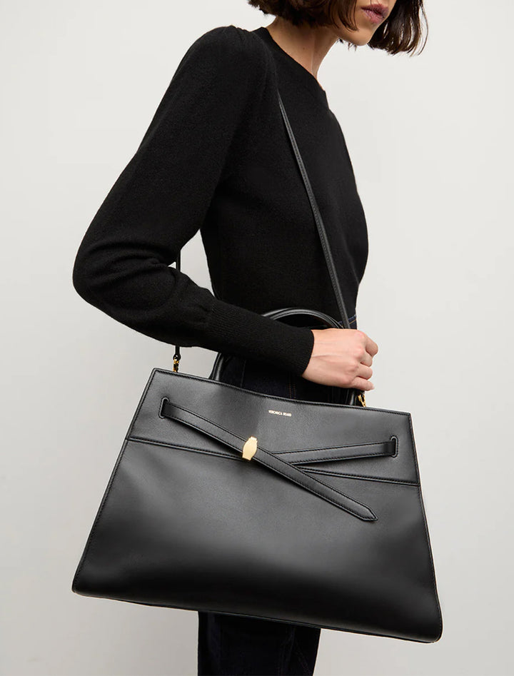 Model carrying Veronica Beard's the work tote large in black.