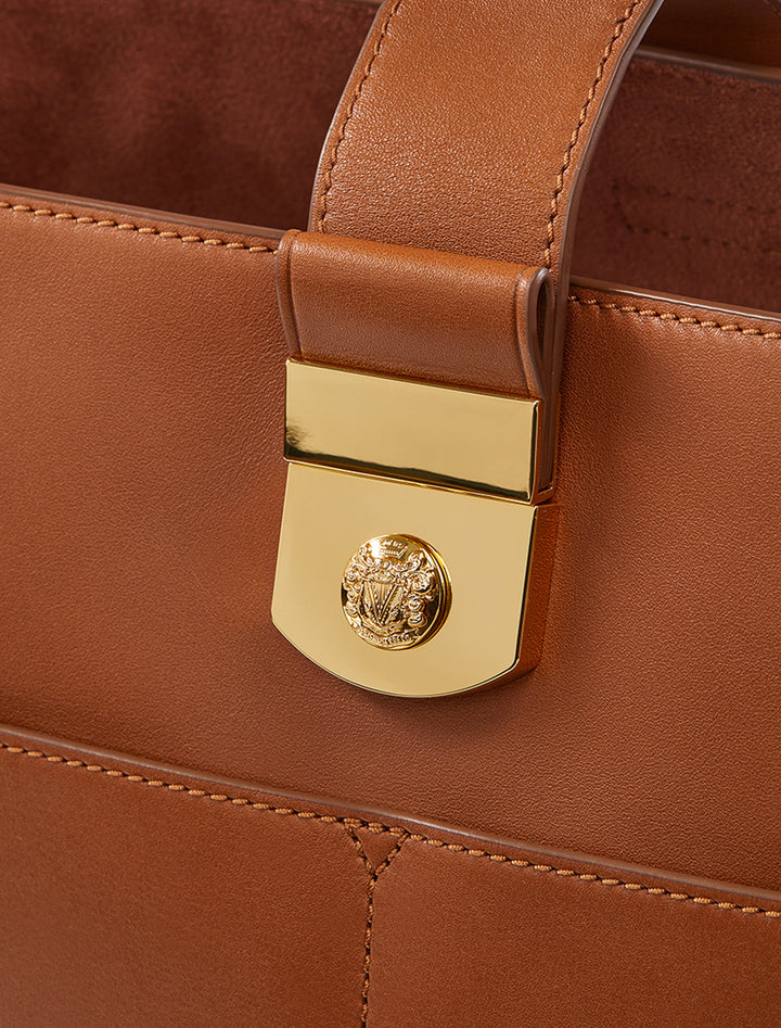 Close-up view of Veronica Beard's the small crest lock bucket bag in hazelwood.