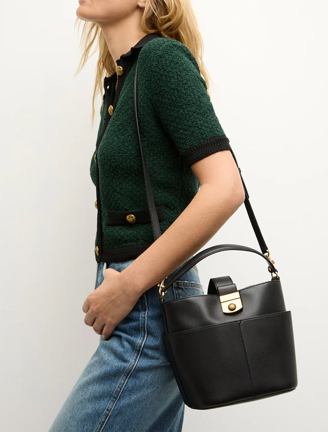 Model wearing Veronica Beard's the small crest lock bucket bag in black on her shoulder.