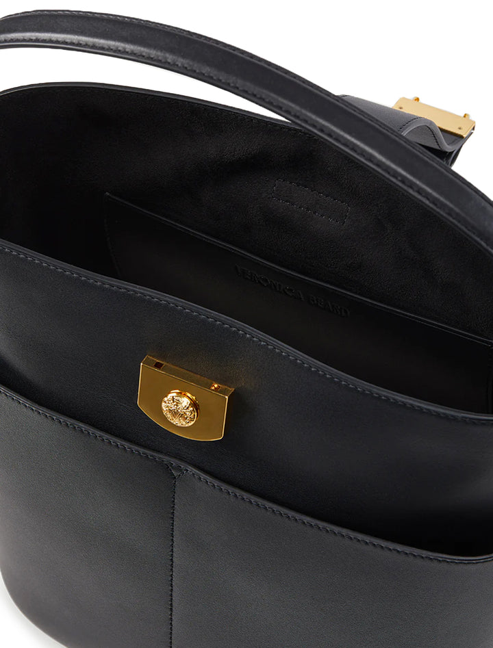 Close-up view of Veronica Beard's the small crest lock bucket bag in black.