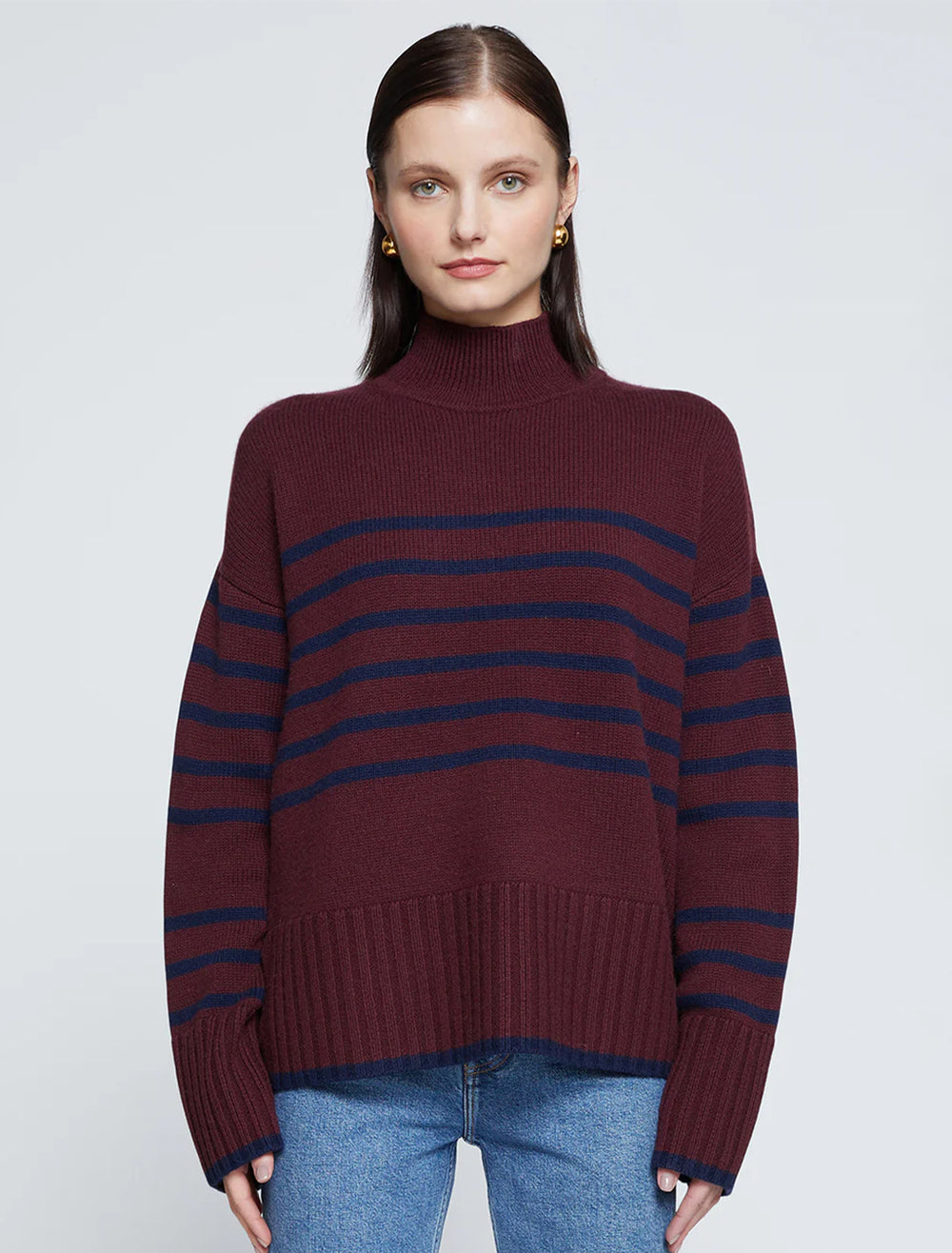 Model wearing Stateside's striped mockneck sweater in cherry liquor.