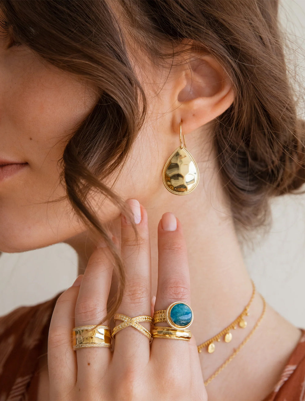 Model wearing Anna Beck's medium hammered teardrop earrings in gold.