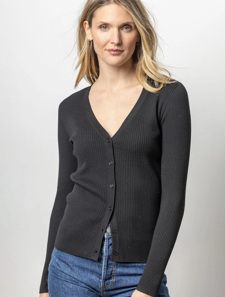 Model wearing Lilla P.'s ribbed cardigan sweater in black.