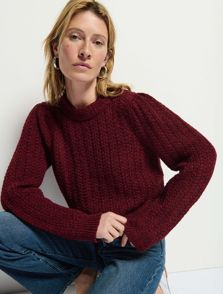 Model wearing Nation LTD's eboni mock neck sweater in danish red.