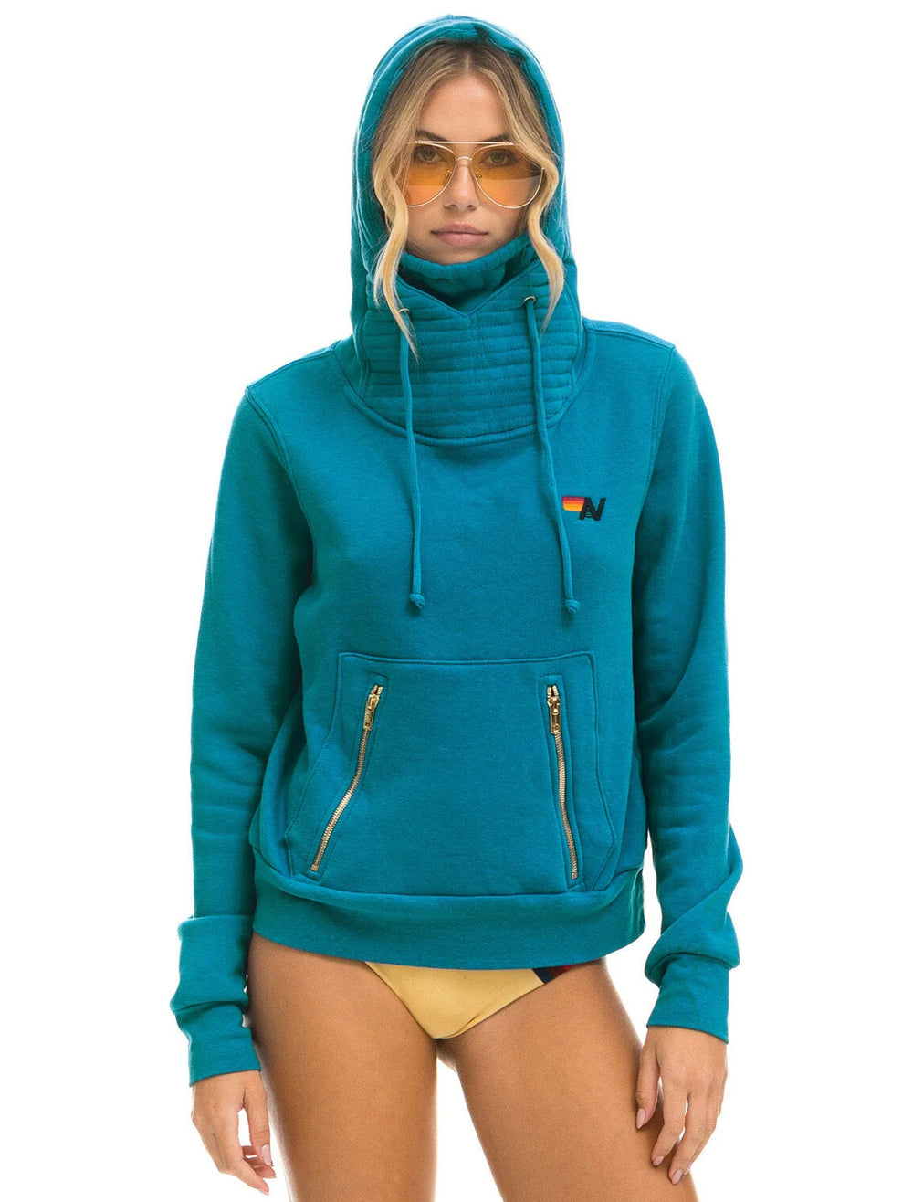 Model wearing Aviator Nation's ninja hoodie in teal.