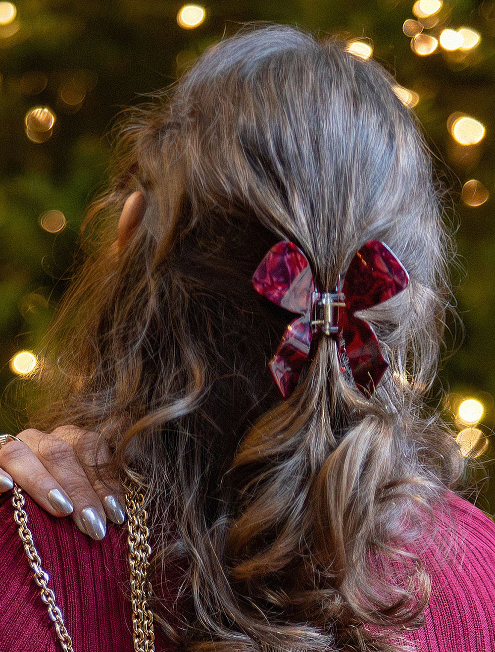Model wearing MLE's bow hair claw in burgundy.