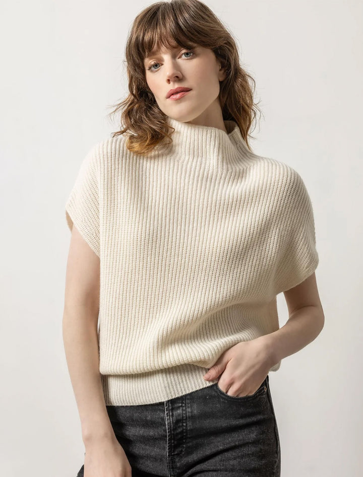 Model wearing Lilla P.'s ribbed funnel neck sweater in ivory.