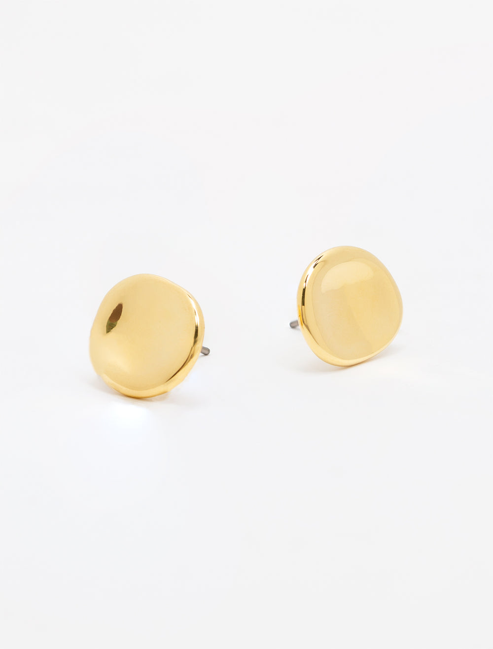 Close-up view of concave gold button earrings