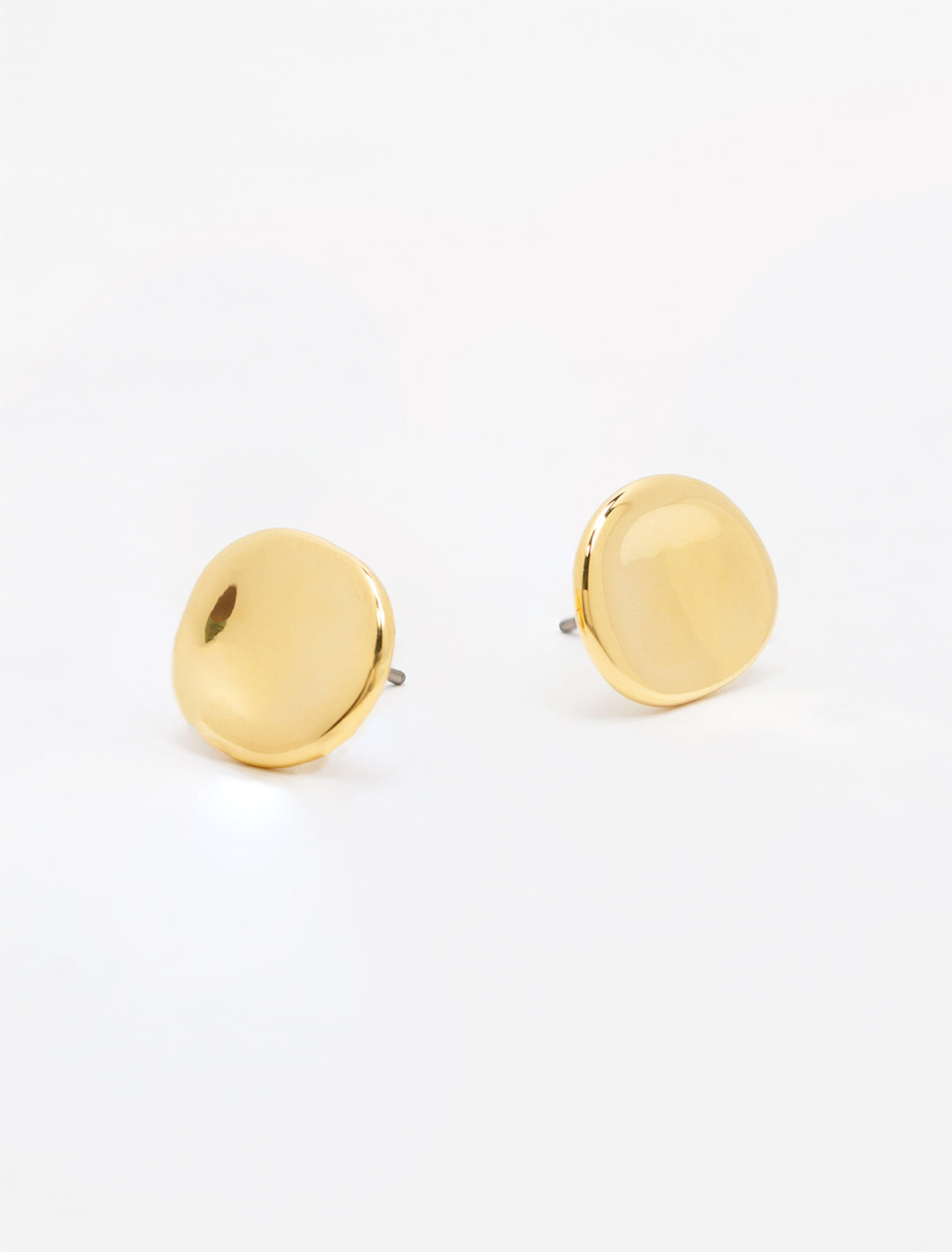 Close-up view of concave gold button earrings