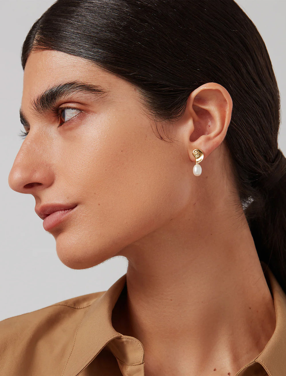 Model wearing Jenny Bird's lucille earrings in gold.