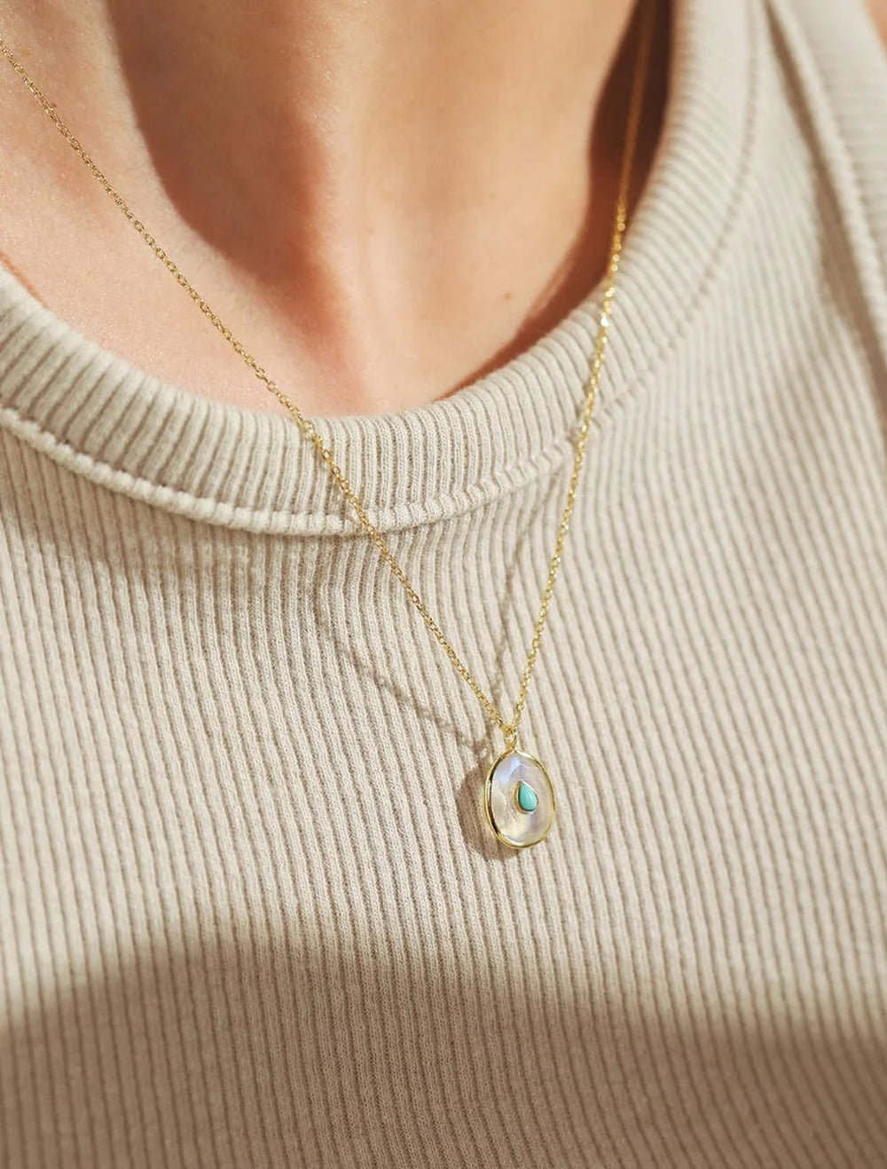 model wearing oval opal pendant necklace in gold