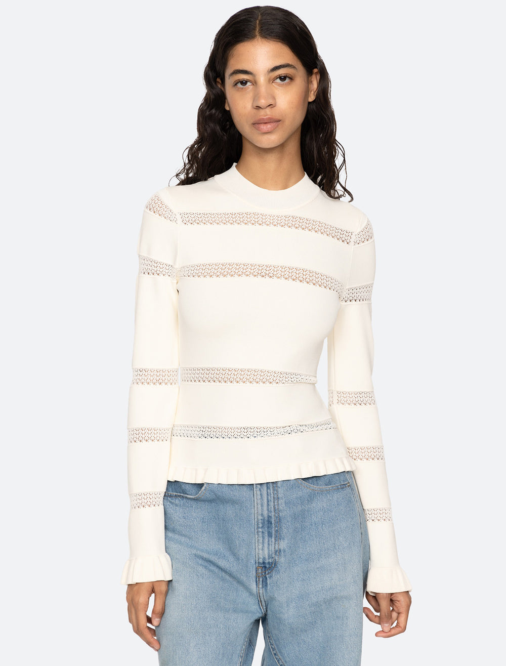 Model wearing Sea NY's devon knit long sleeve top in cream.