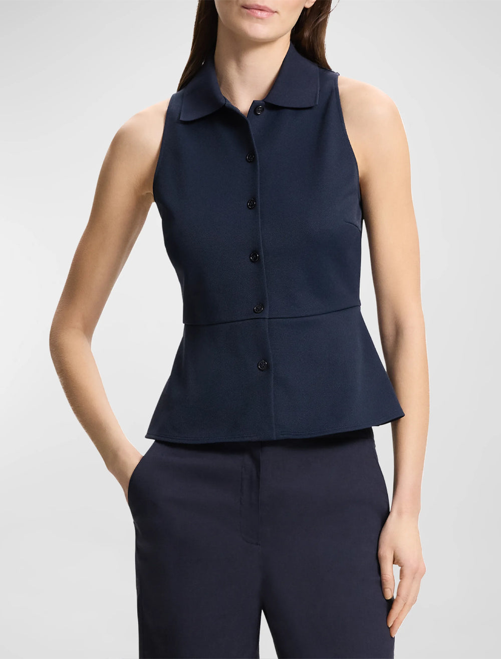 Model wearing Theory's summer button down peplum top in navy.