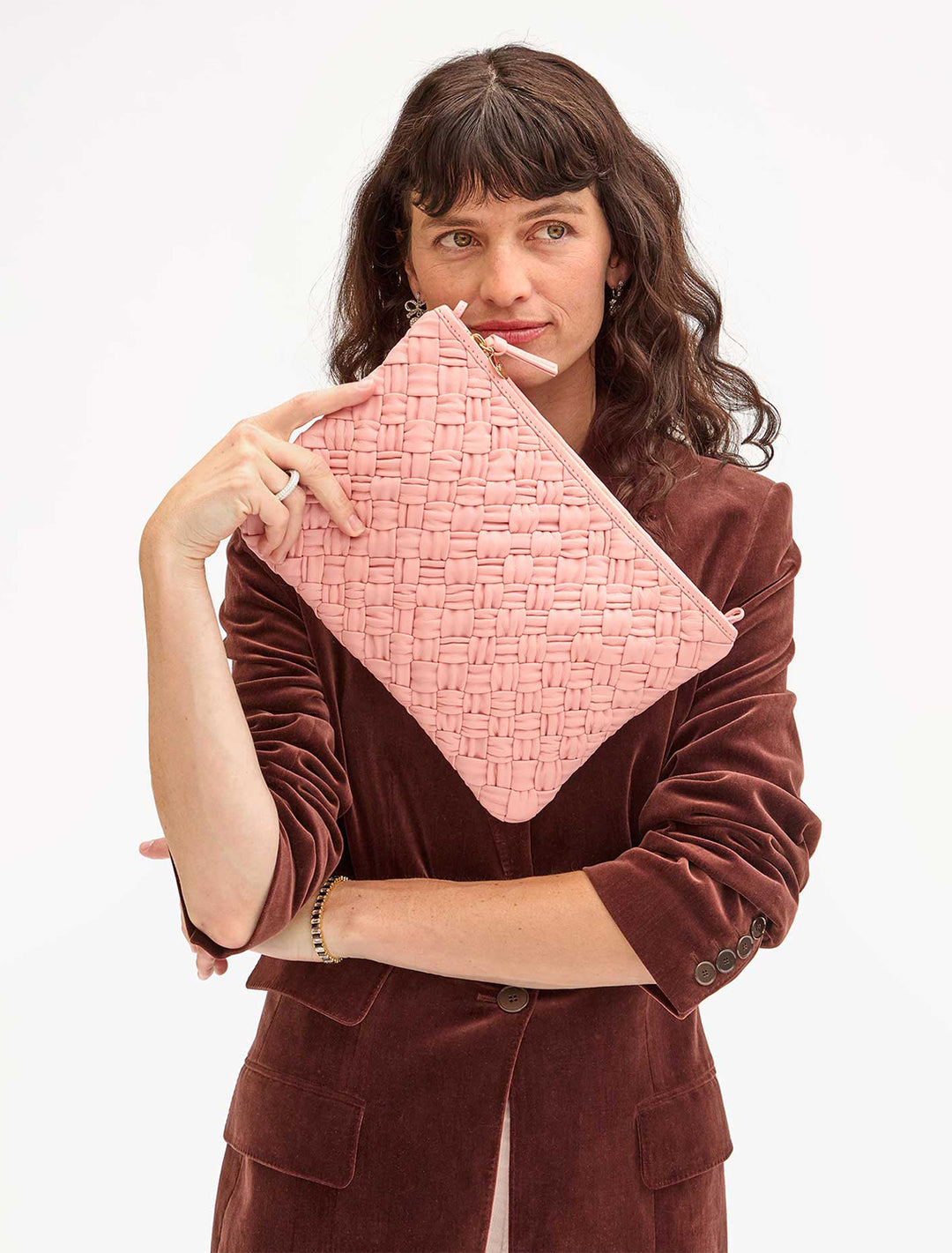 model holding flat clutch in blush puffy woven