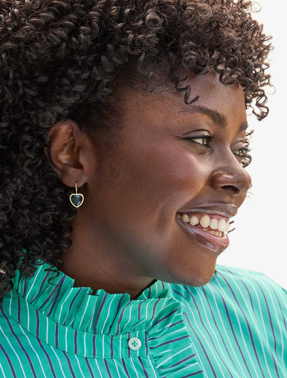 model wearing bezel heart earrings in sapphire blue crystal