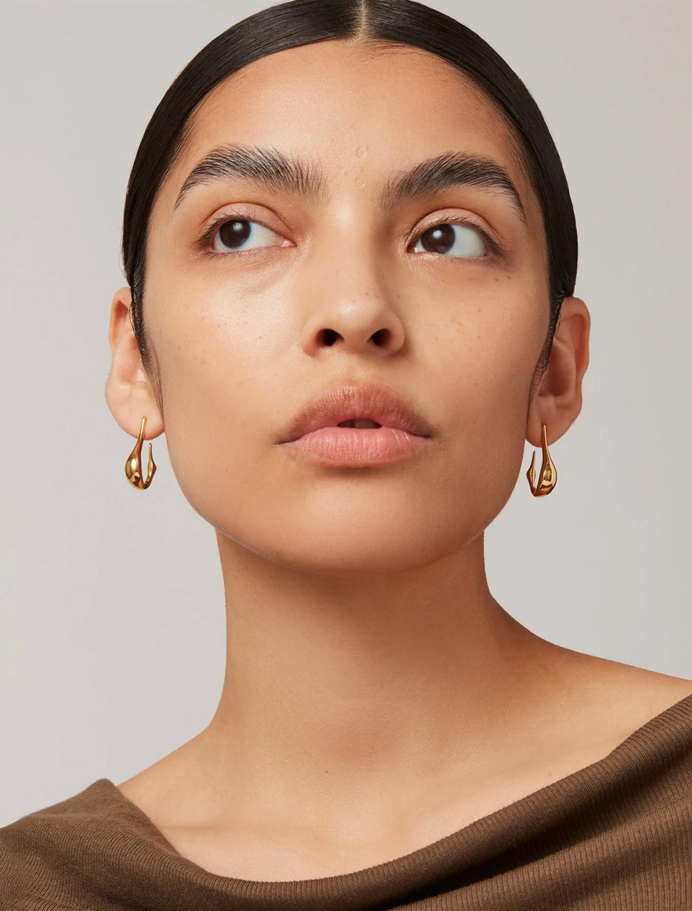 Model wearing Jenny Bird's colette small earrings in gold.