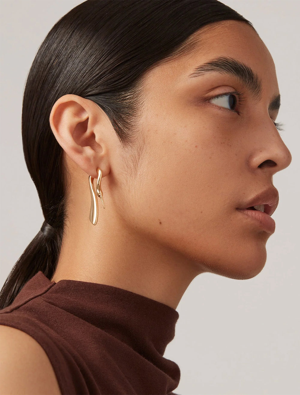 Model wearing Jenny Bird's lisieux ear jackets in gold.