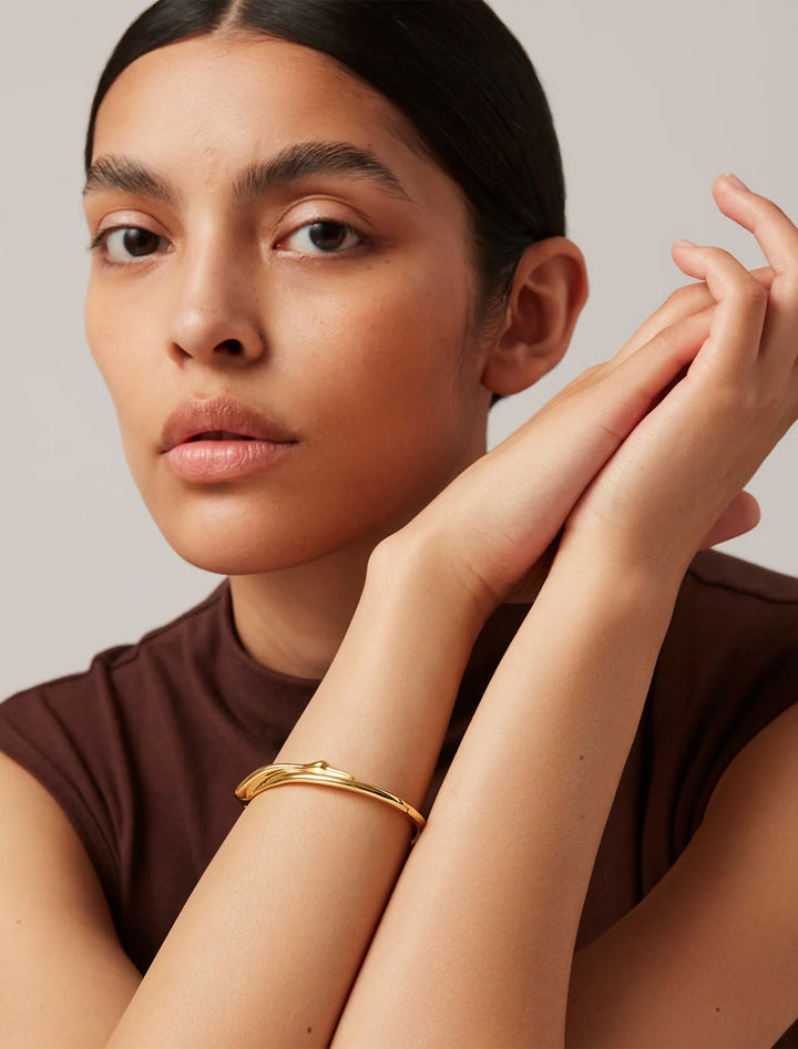 Model wearing Jenny Bird's colette bangle in gold.