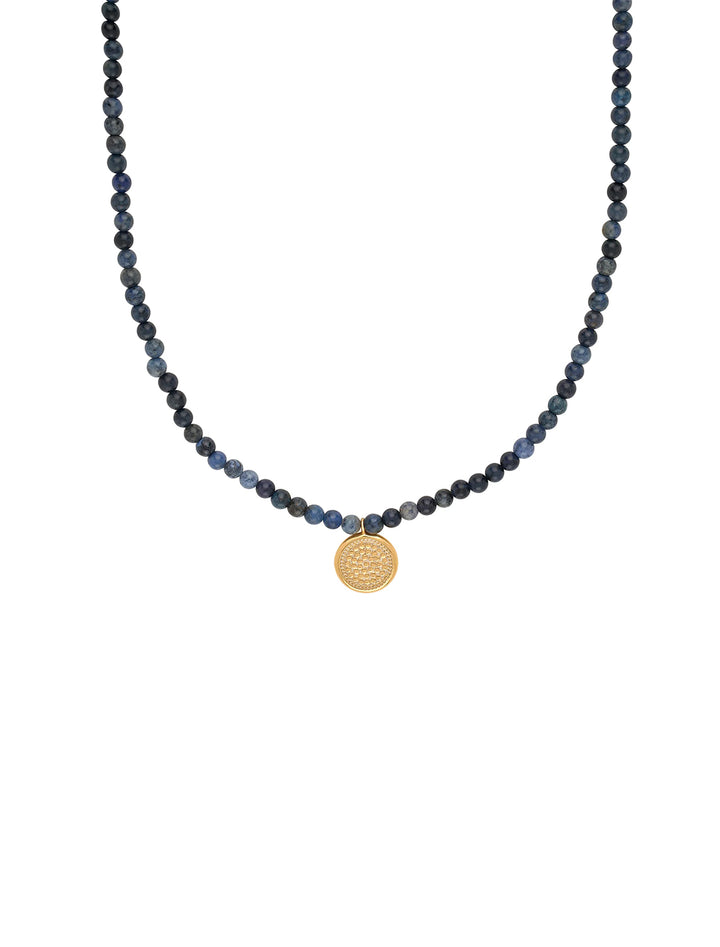 Front view of Anna Beck's dumortierite beaded necklace with medium gold pendant.