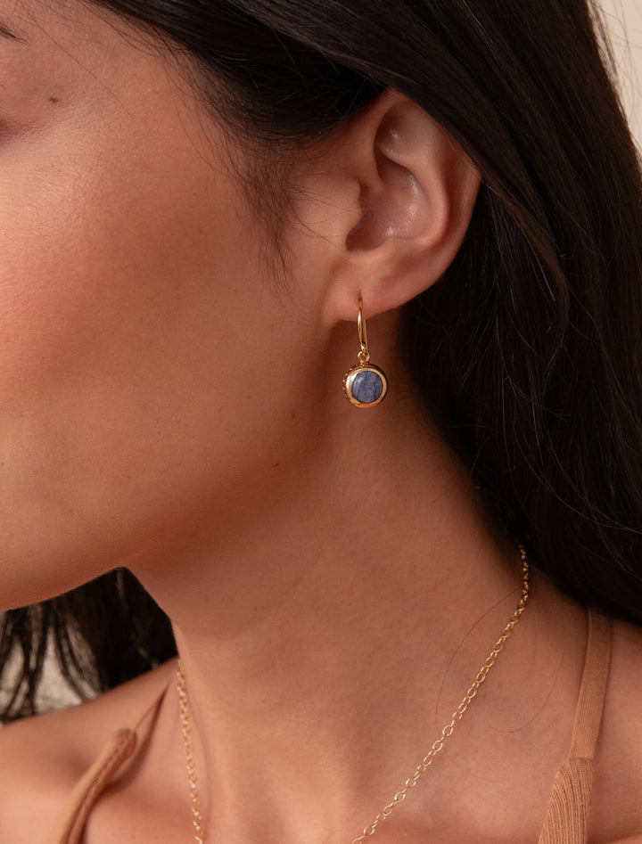 Model wearing Anna Beck's dumortierite circle drop earrings.