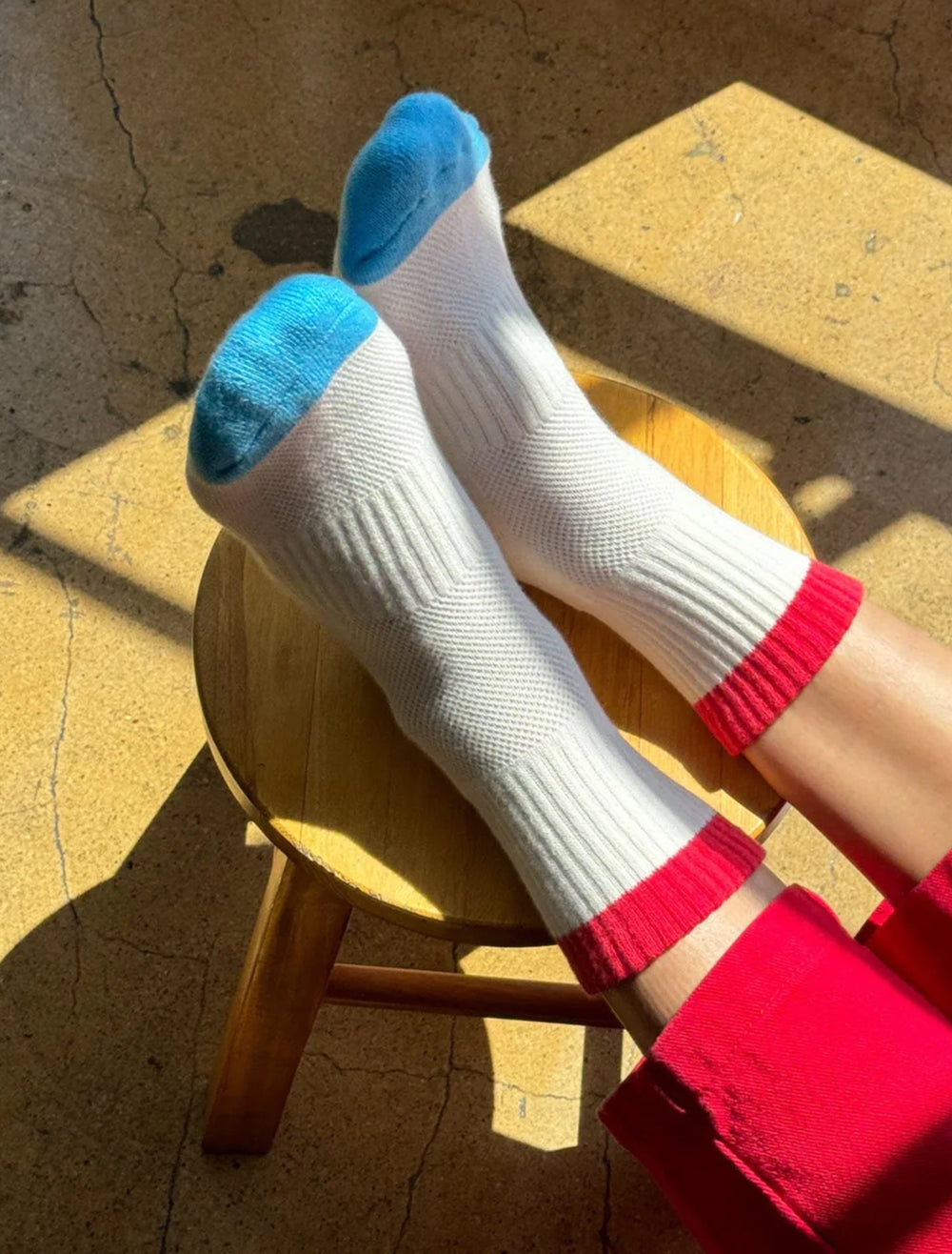 Model wearing Le Bon Shoppe's color block girlfriend socks in blue and red.