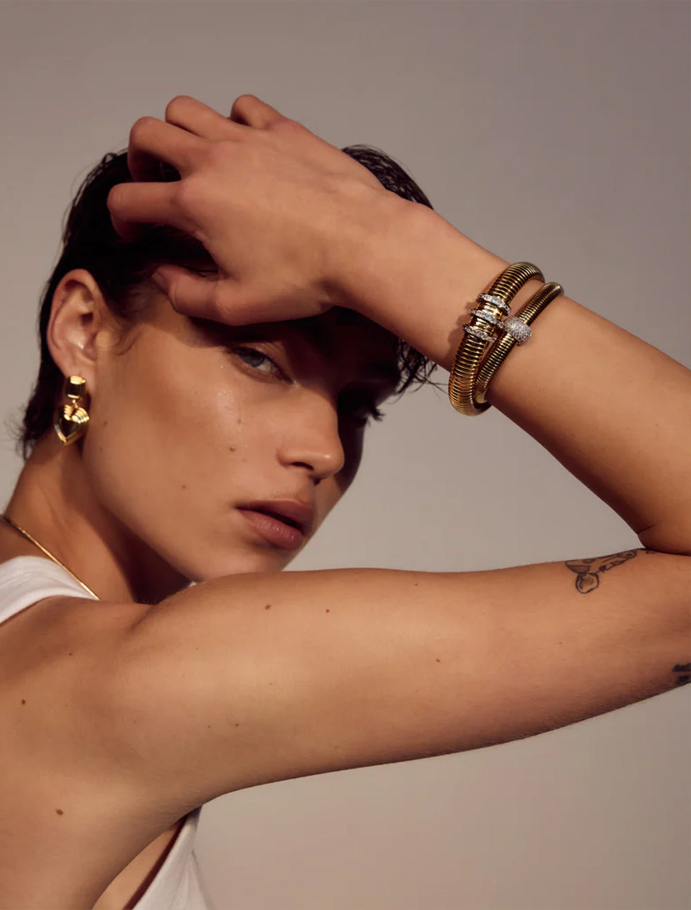 Model wearing LUV AJ's pave trio snake chain bracelet in gold.