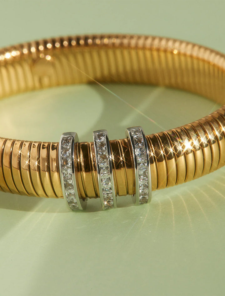 Close-up view of LUV AJ's pave trio snake chain bracelet in gold.