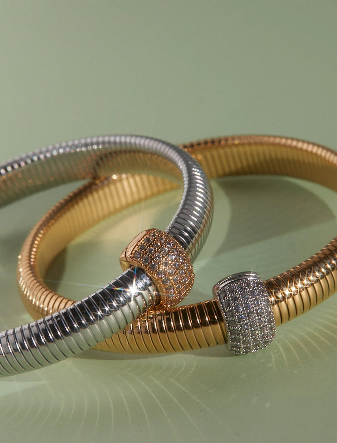 Close-up view of LUV AJ's pave dome snake chain bracelet in gold.