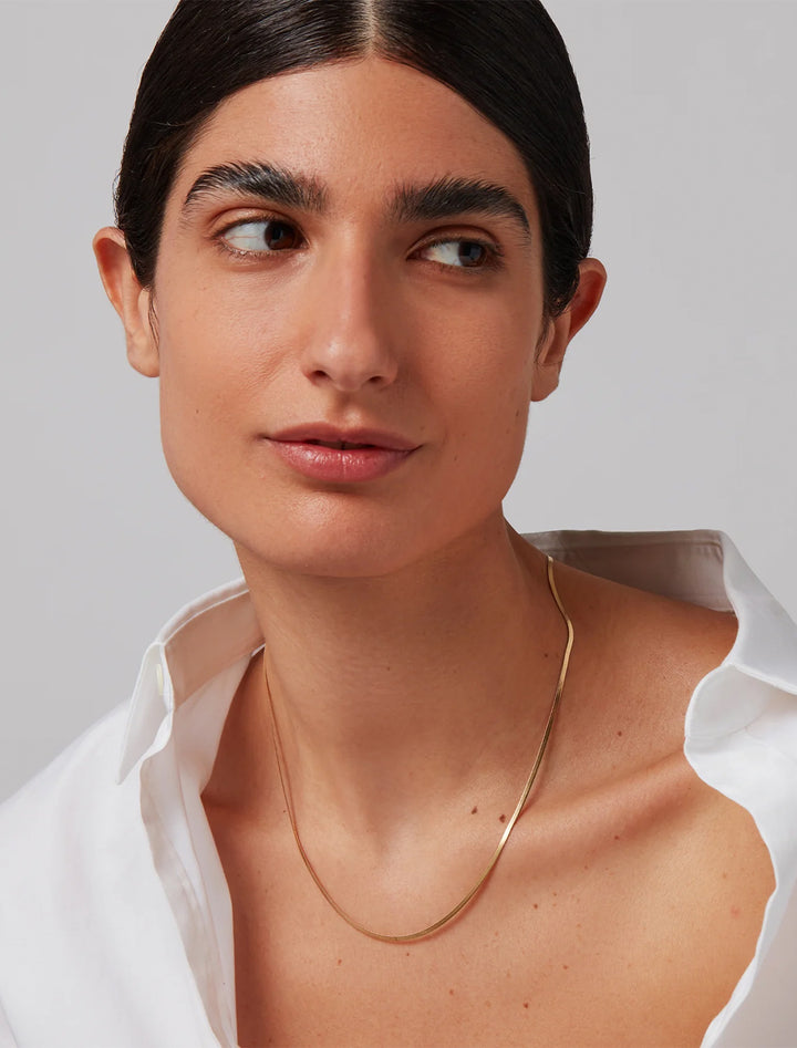 Model wearing Jenny Bird's zeina slim chain in gold.