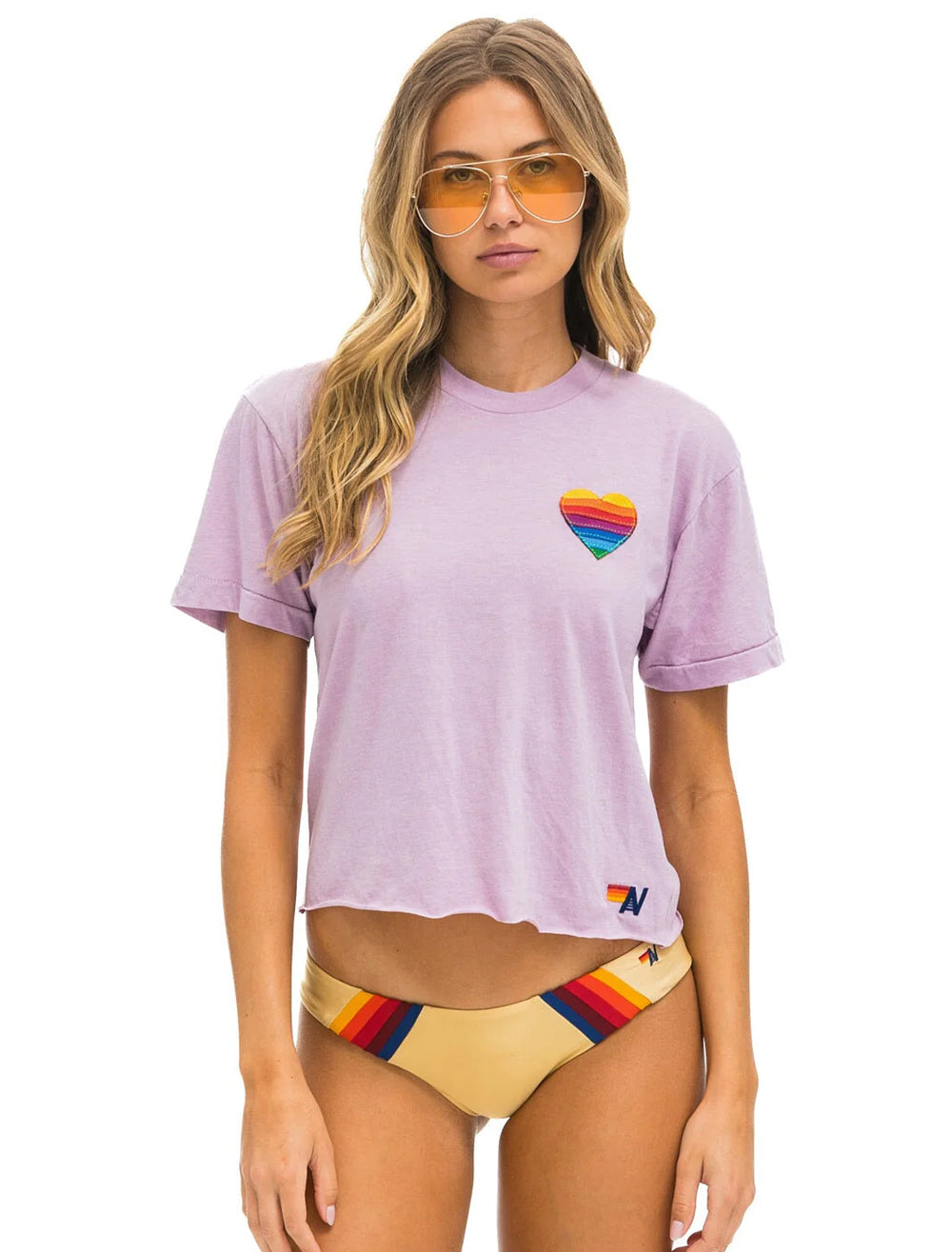 Model wearing Aviator Nation's rainbow heart stitch boyfriend tee in mauve.