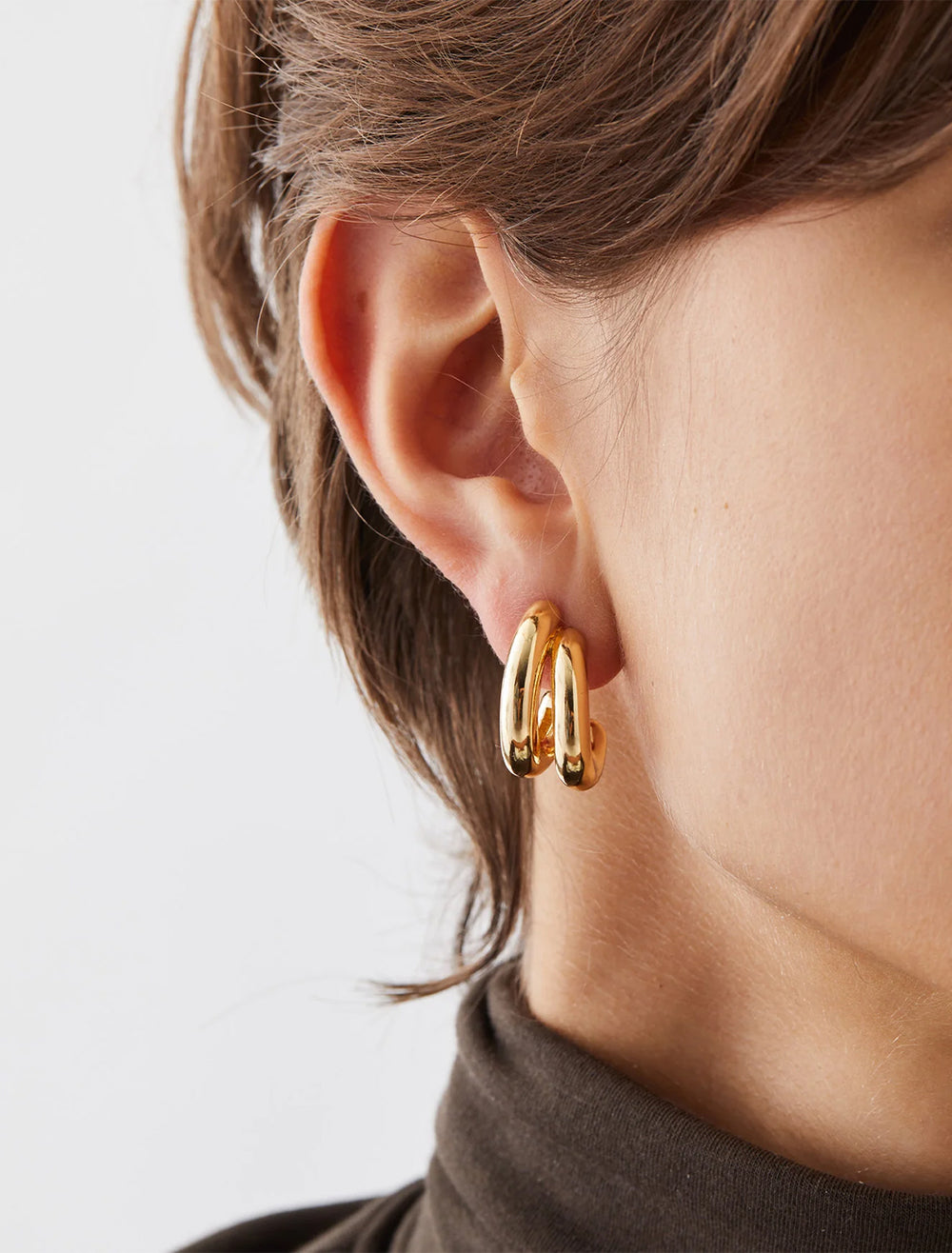 Model wearing Jenny Bird's florence earrings in gold.