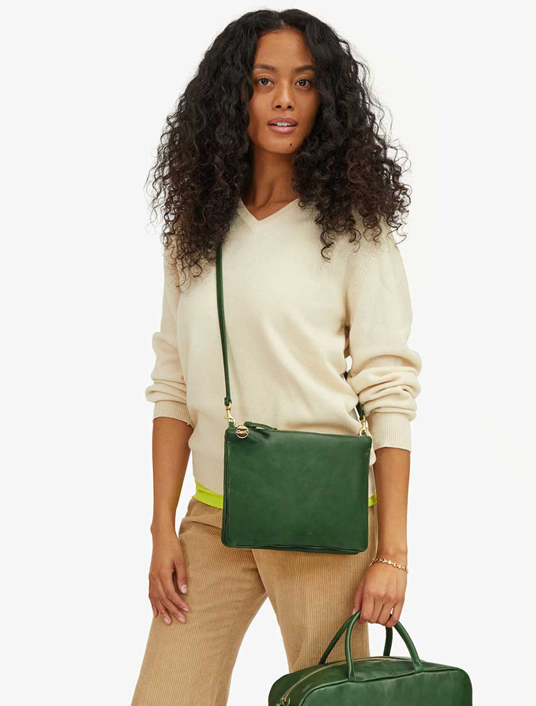 Model wearing Clare V.'s double sac bretelle in evergreen rustic as a crossbody