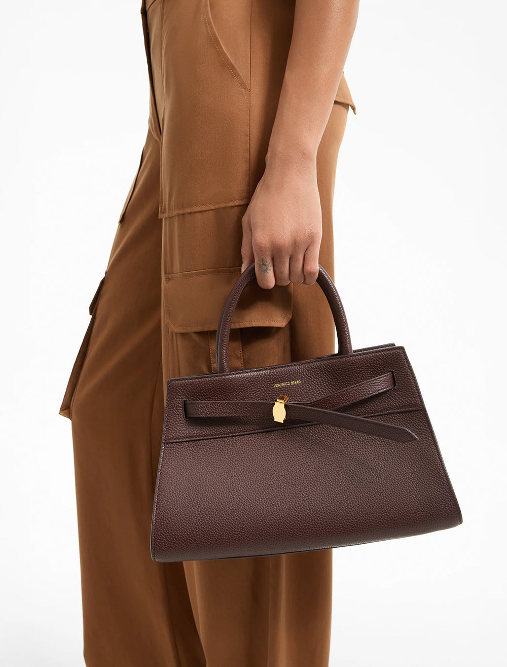 model holding the dash bag in dark raisin