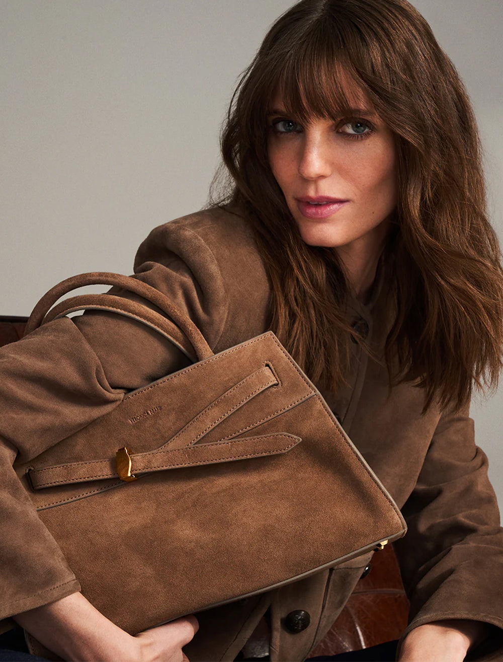 model holding dash bag in bark suede