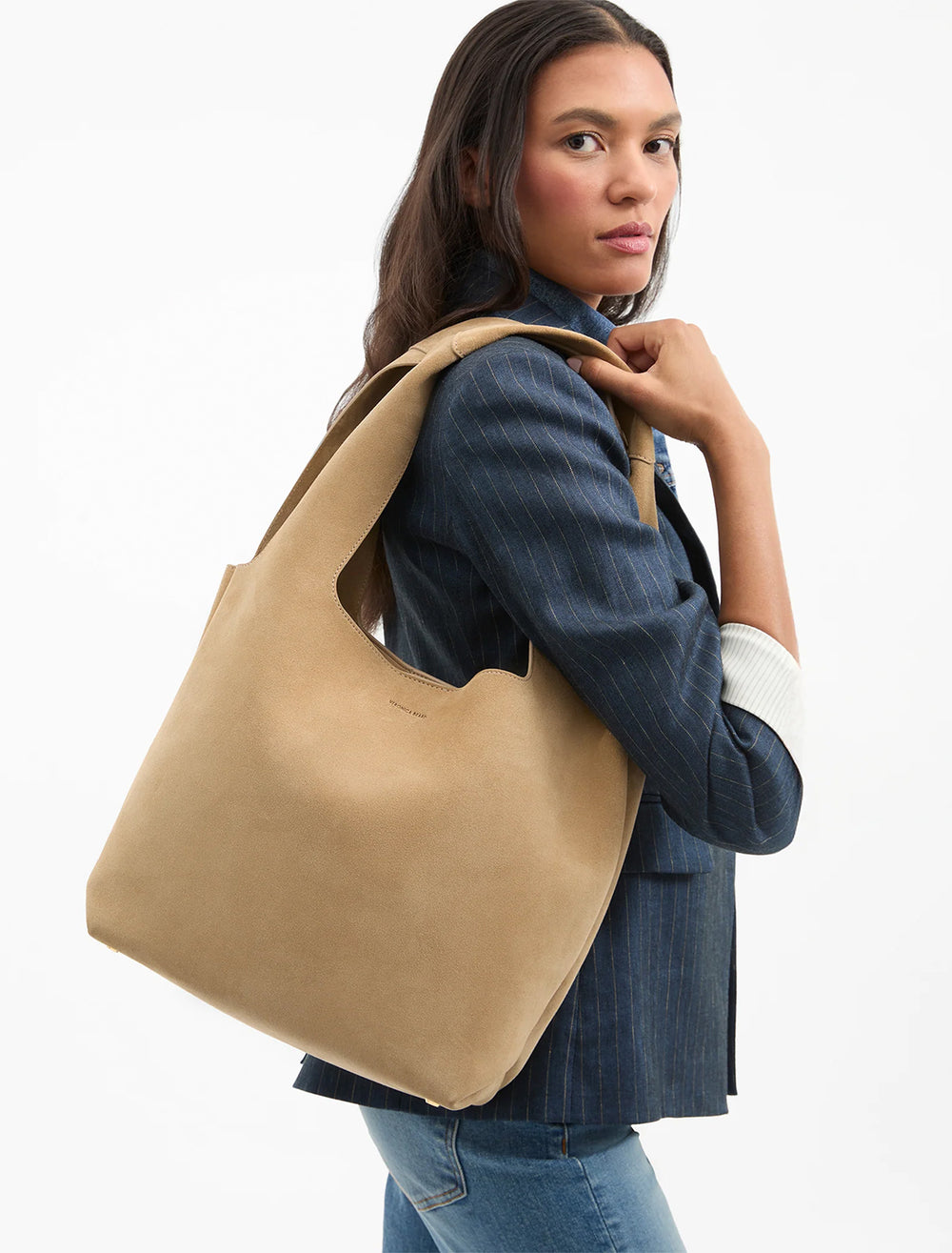 model holding sling bag in latte