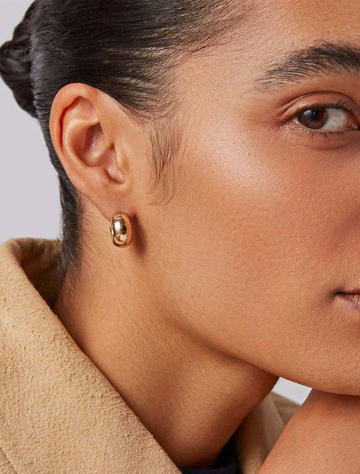 model wearing mini tome hoop earrings in gold