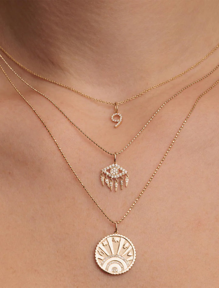 diamond and gold luck coin with rays charm