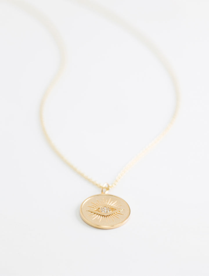 Close-up view of Sydney Evan's protective eye coin charm on heavy tiffany.