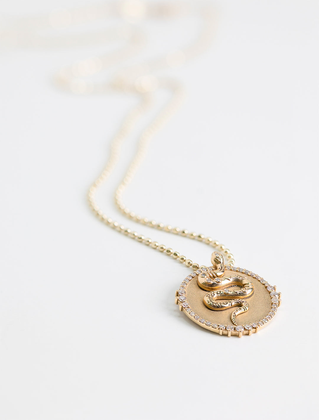 Close-up view of Sydney Evan's snake coin charm on heavy bolita.