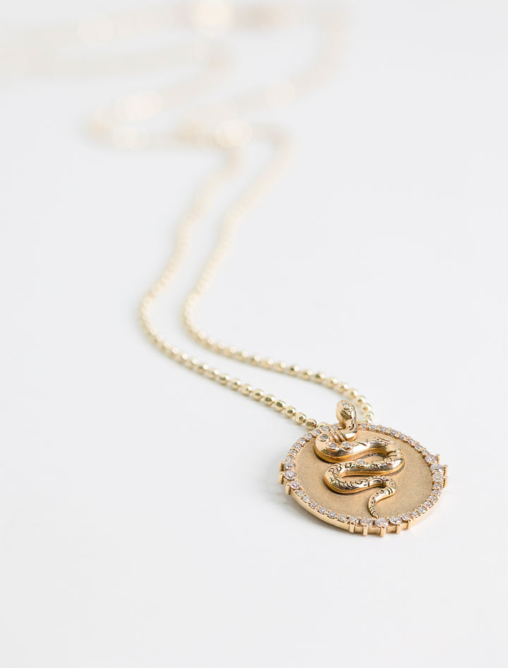 Close-up view of Sydney Evan's snake coin charm on heavy bolita.