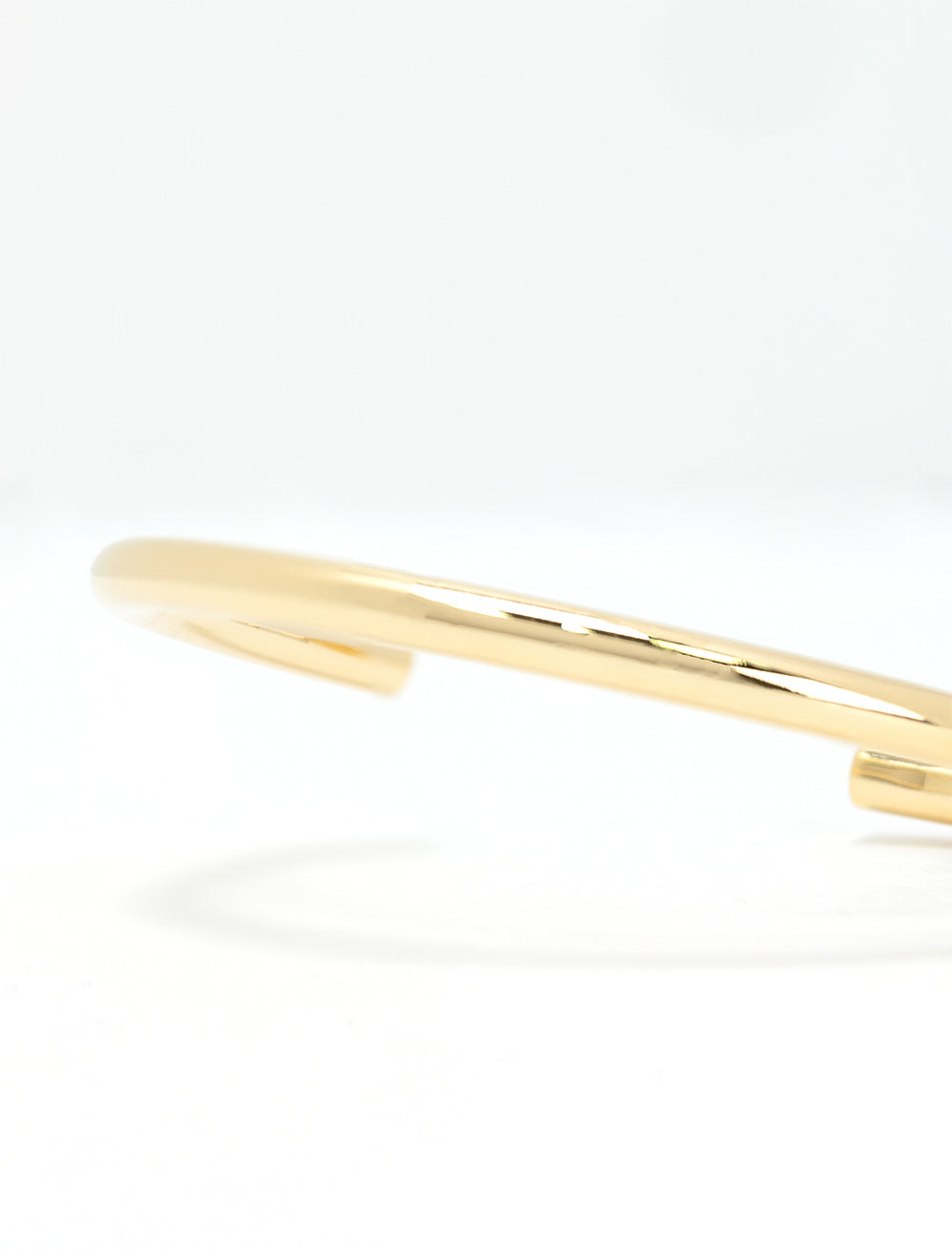 Close-up view of AV Max plain cuff in gold.