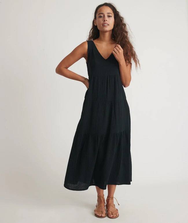 model wearing corinne dress in black with tan sandals