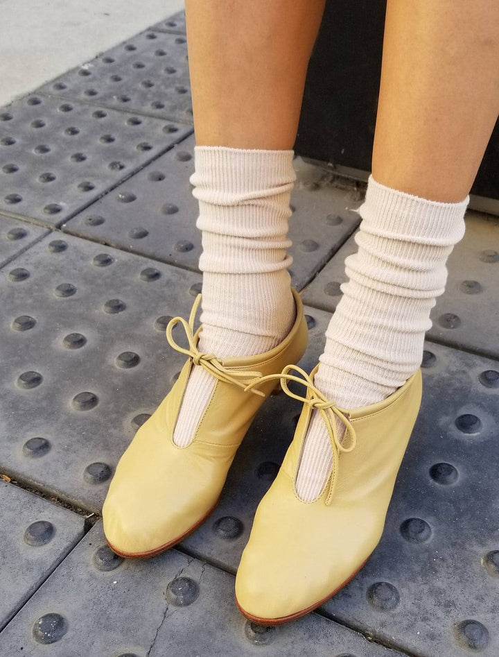 model wearing trouser socks in eggnog with yellow heels