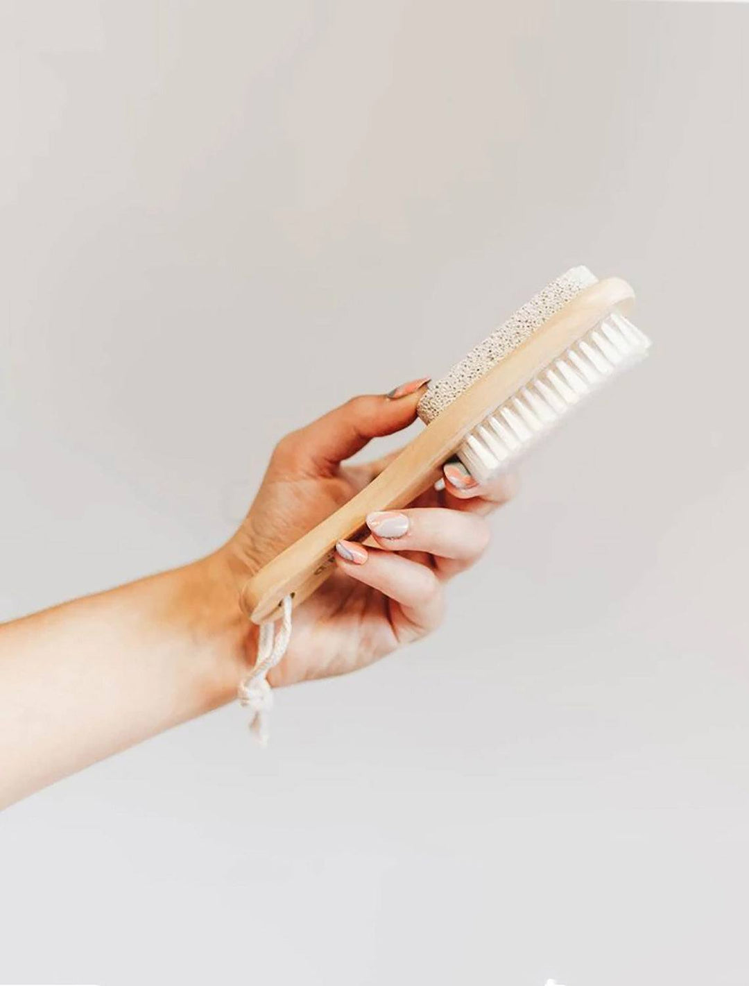 model holding bkind wooden pumice brush