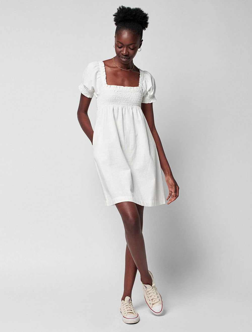 model wearing ramona dress in egret with white sneakers
