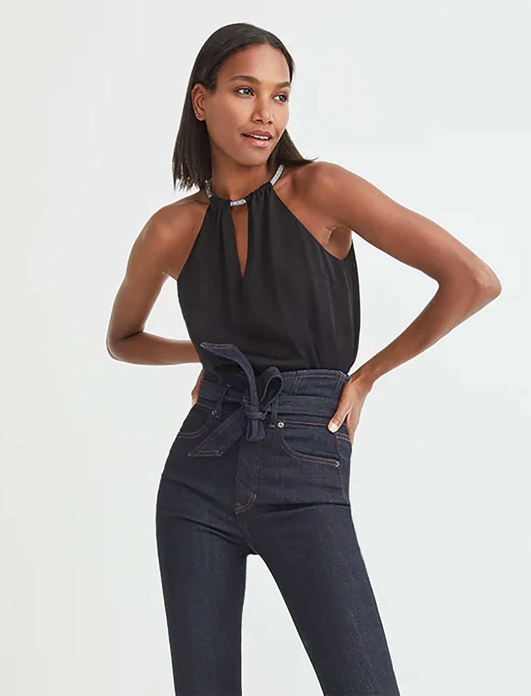 Model wearing Veronica Beard's Kusumi Top in Black. Model pairs the tank with a pair of dark wash jeans.