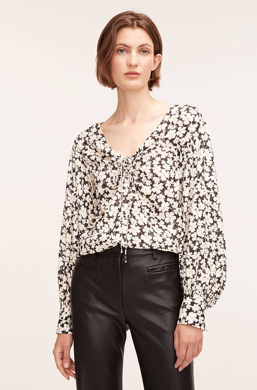 Model wearing Rebecca Taylor's Drawstring Long Sleeve Blouse in Paige Fleur Black Combo. Model styles the blouse with high-waisted leather pants.