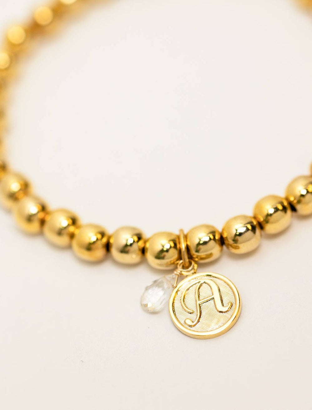 close up view of beaded monogram bracelet | A charm and gem
