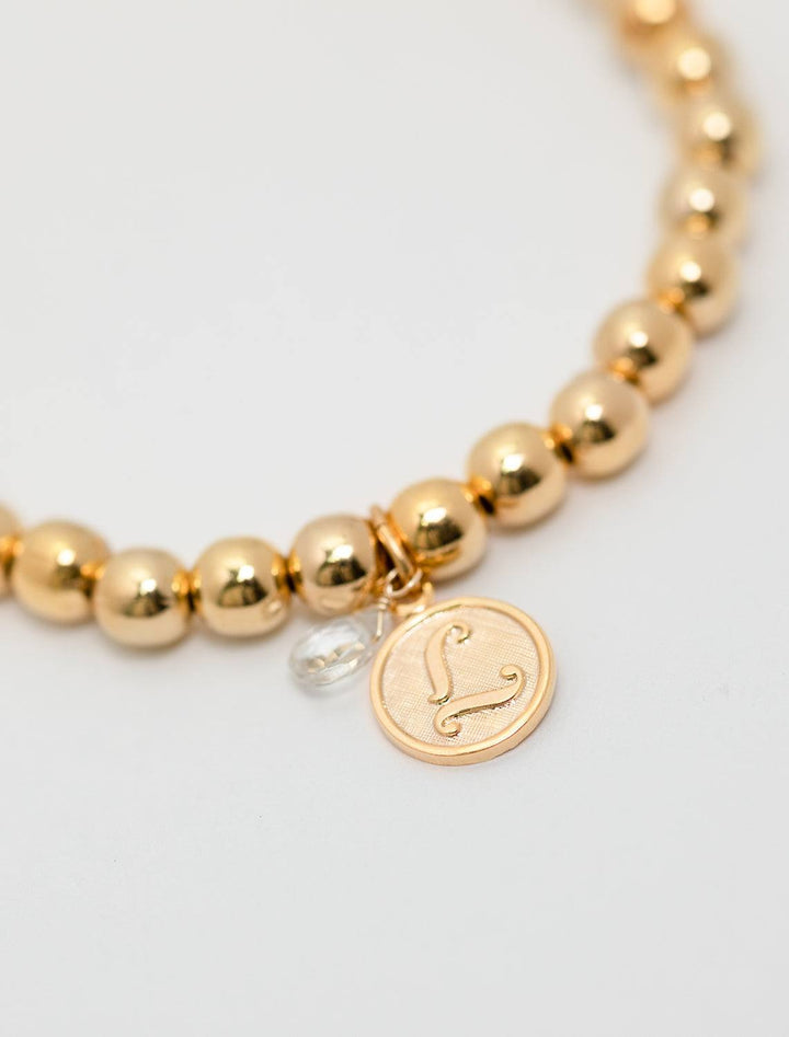 close up view of beaded monogram bracelet | L charm and gem