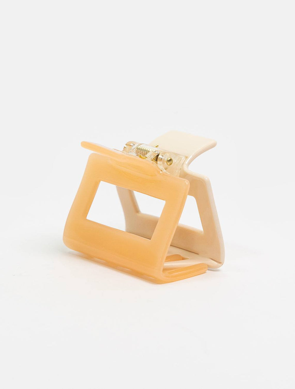 detailed view of two tone claw. shows one side of claw is peach and one is a light beige.